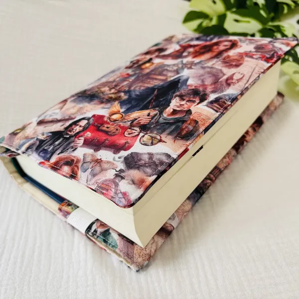 Funda artesanal de tela colocada sobre libro abierto, con vista lateral que muestra su ajuste cómodo y protección completa