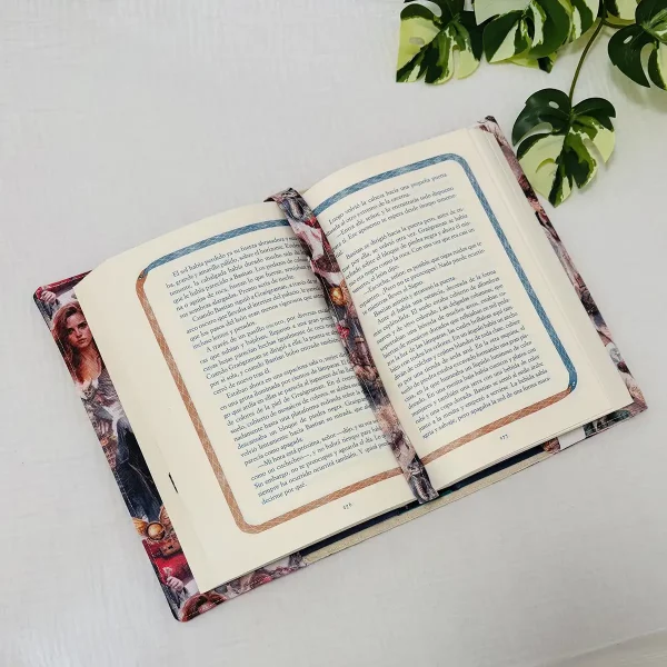 Funda de tela artesanal sosteniendo un libro abierto, con solapas ajustadas que mantienen las cubiertas en su sitio.