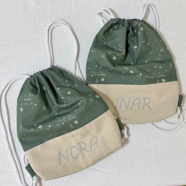 Mochilas infantiles personalizadas con nombre bordado, confeccionadas a mano en tela de algodón verde y beige, con cordones blancos ajustables