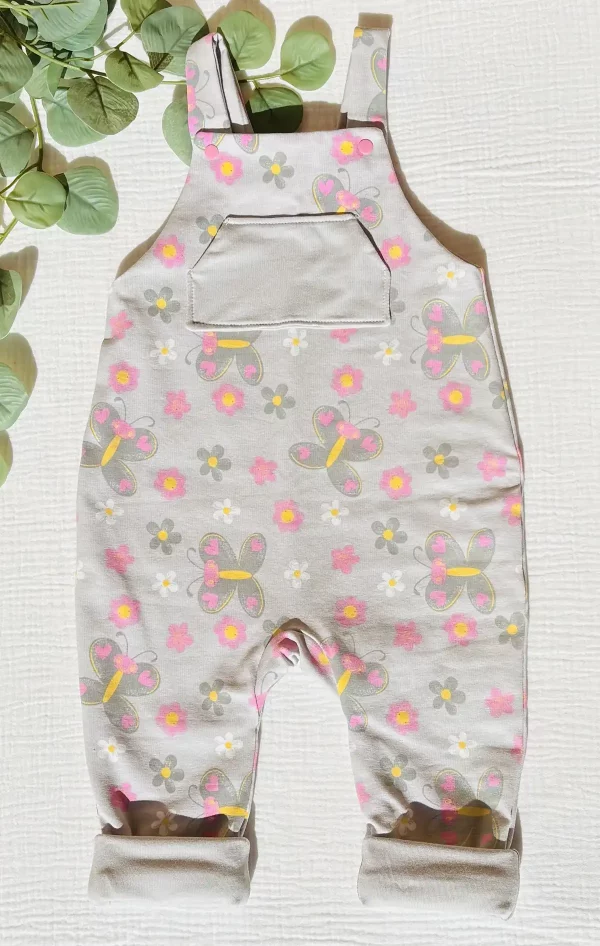 Peto infantil gris con estampado de mariposas y flores que revela detalles con la luz