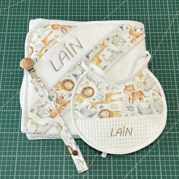 Babero personalizado para bebé con estampado de animales de la selva y nombre bordado en algodón blanco con textura waffle.